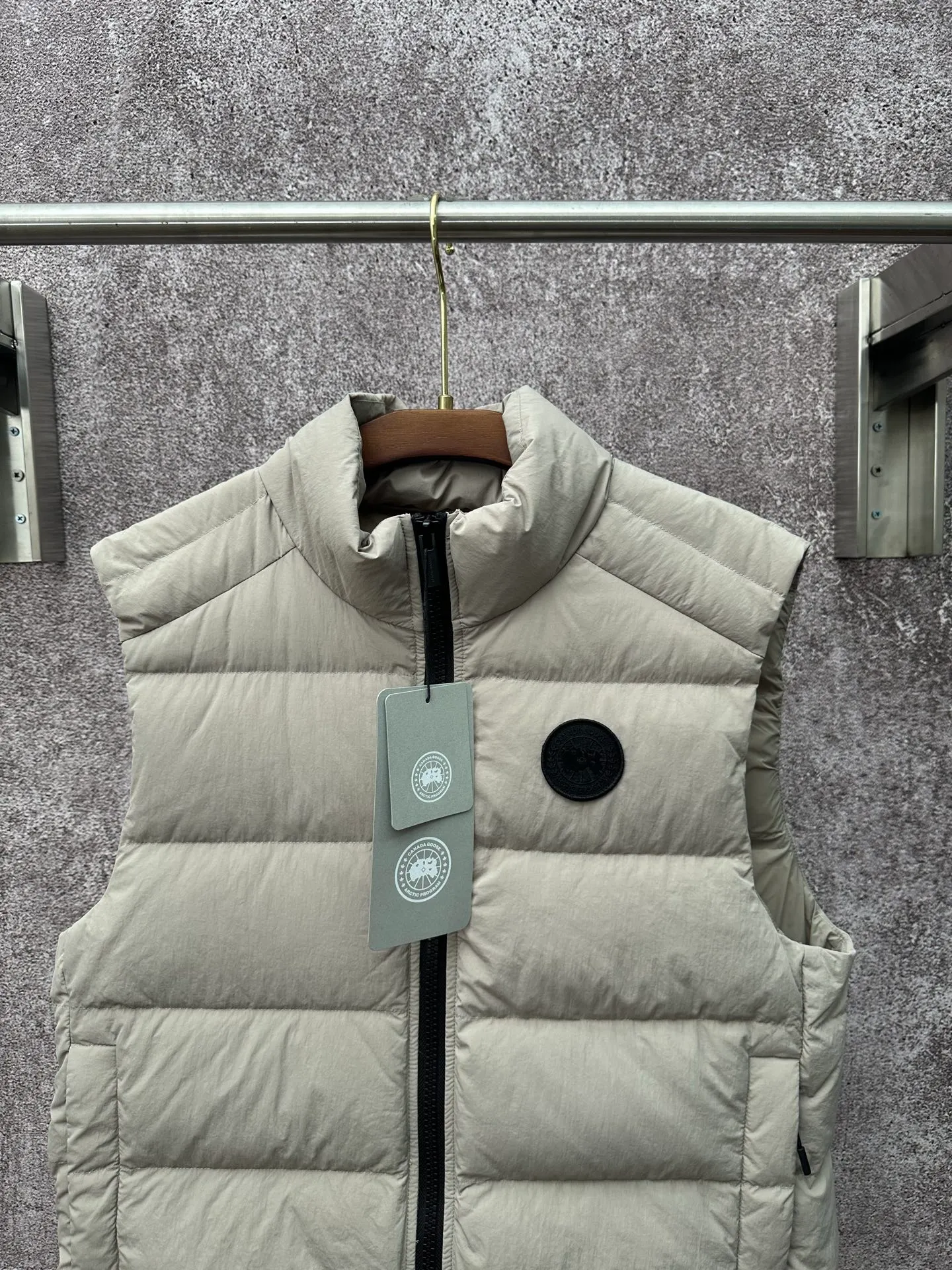 P720 Canada Goose Badge Down Vest Fabric selection: The use of high-quality protective nylon fabric not only enhances the wear resistance of the surface, but also takes into account wind resistance, ensuring excellent performance in various harsh weather conditions.  90 national standard high-quality white duck down: selected high-loft down, weighing 160g, light and warm, with excellent temperature locking performance and good resilience.  Three-dimensional quilting process: Precision thread reinforcement to prevent velvet drilling and ensure that the fluffy and resilient elasticity lasts as new.  Details: The ribbon is woven with polyester as the base, and the brand letters are decorated on the ribbon through high-precision computer embroidery. The edges of the pattern are clear, the stitches are fine and even, and multiple layers of embroidery thread are stacked to enhance the three-dimensional effect. Accessories: One-to-one customized logo, one-to-one customized zipper puller, one-to-one customized three-label SIZE: S M L XL